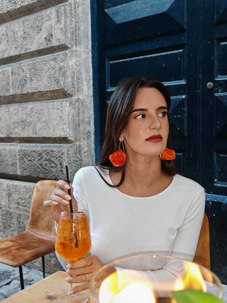 Dolce Vita orange Tramonto paper mache earrings worn in Lecce